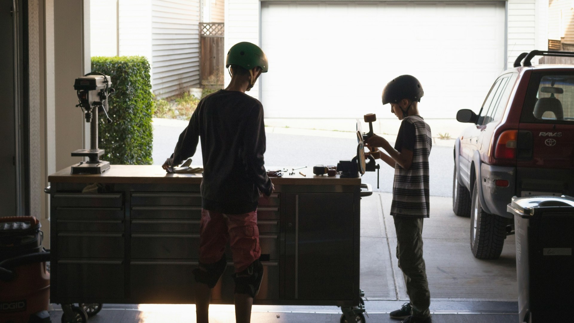 Garage indelen met werkbank waar twee kinderen met gereedschap werken en overzicht creëren