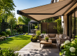 Moderne tuin met terrasoverkapping en knikarmscherm voor comfortabele schaduw op zonnige dag
