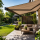 Moderne tuin met terrasoverkapping en knikarmscherm voor comfortabele schaduw op zonnige dag
