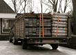 Aanhanger met bouwmateriaal geladen achter auto