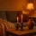 Gezellige najaarsstyling interieur met warme kaarsen, beige plaid en gedroogde takken